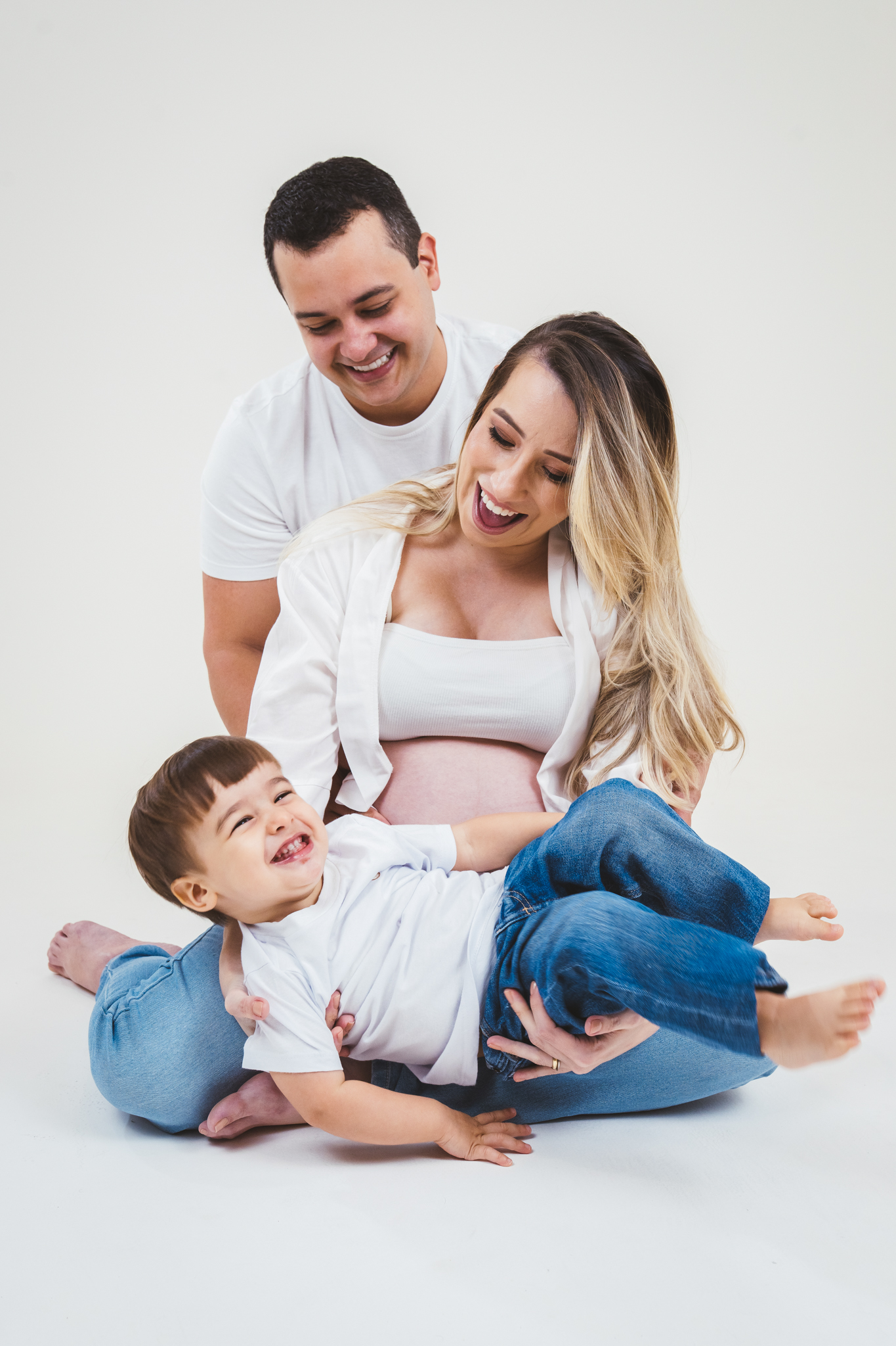 Mãe, pai e fiilho em momento de carinho durante ensaio de gestante em Fortaleza
